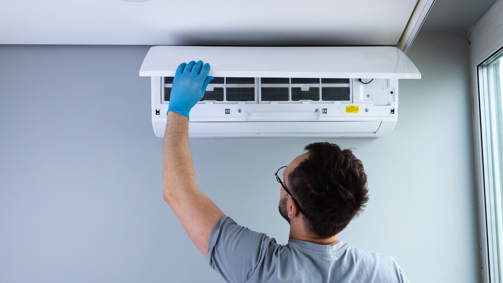 Engineer installing domestic air conditioning unit